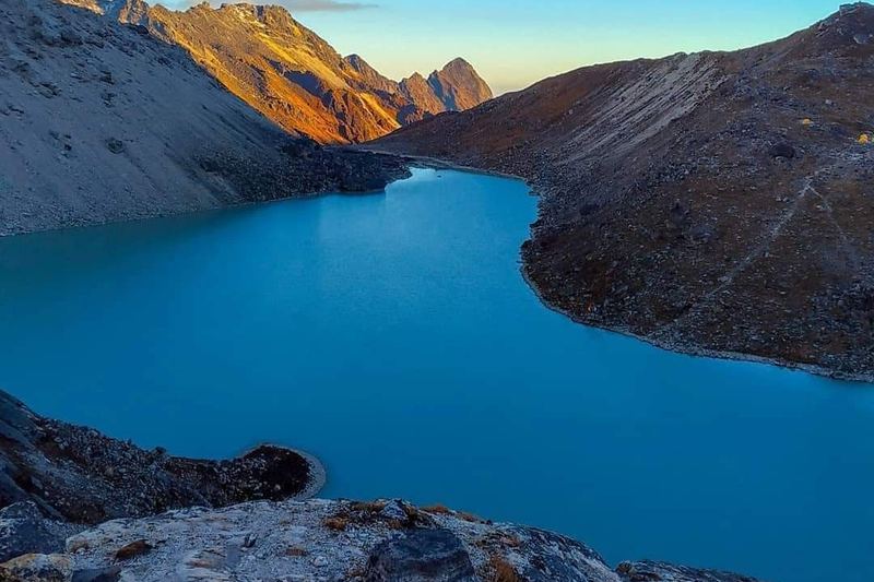 Turquoise high-altitude lake between rocky Himalayan slopes in Sikkim